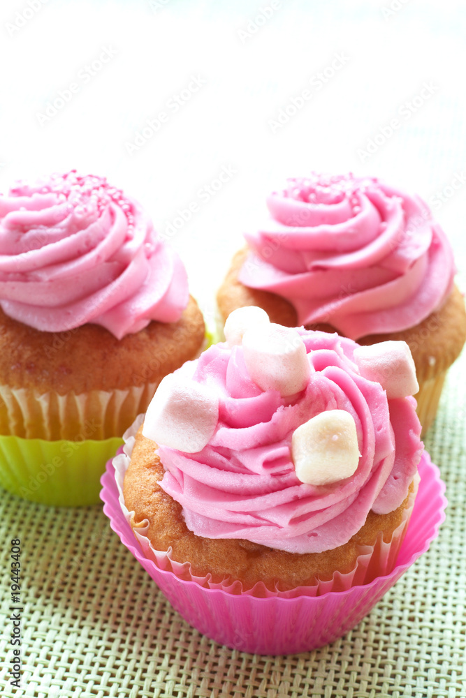 Small vanilla cupcakes with strawberry icing