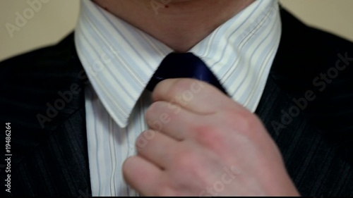 man tightens his tie