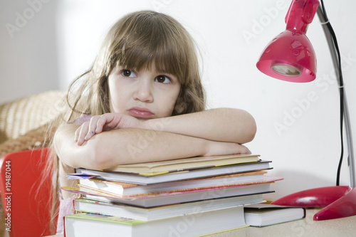 tired little girl put her hand on book photo