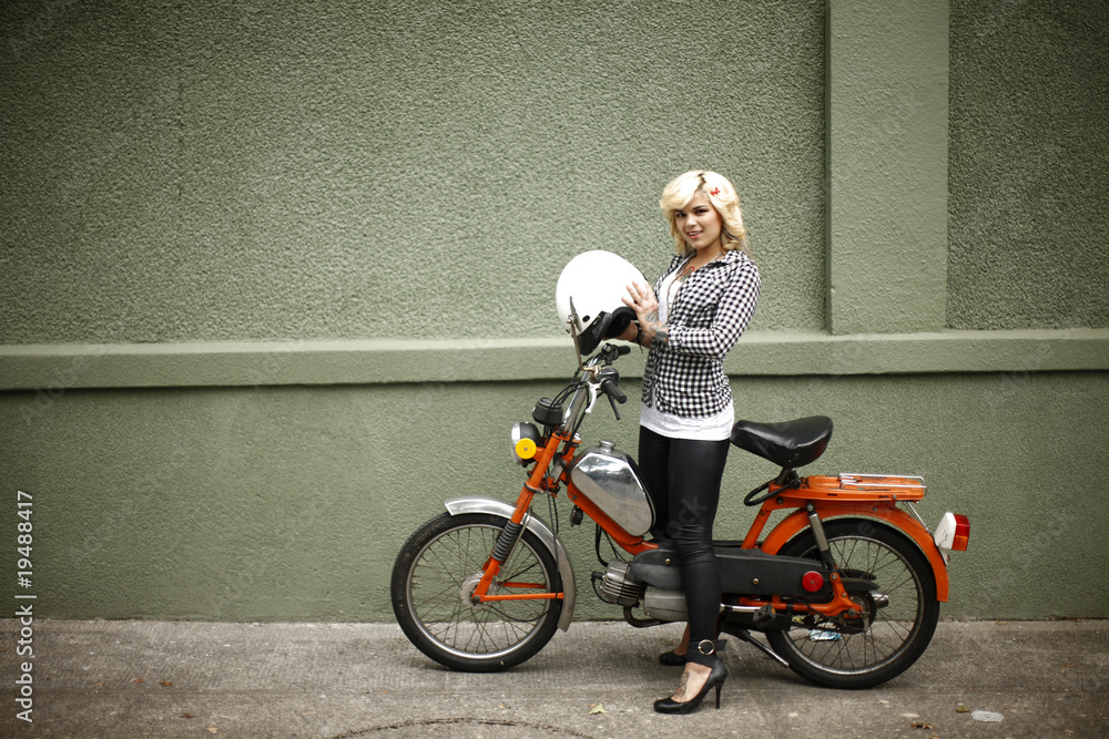 Sexy woman on a moped. StockFoto Adobe Stock