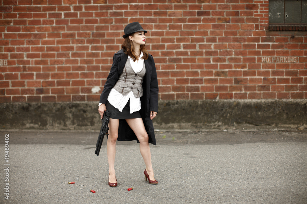 A young and stylish woman holding a shotgun. A young and stylish woman holding a shotgun.