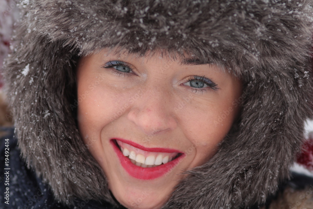 Young woman in fur hat smilling on the snow Young woman in fur hat smilling on the snow