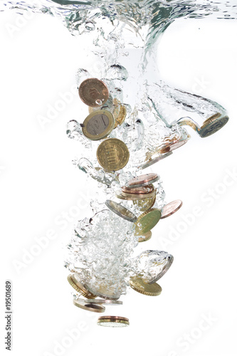 Euro coins falling into the clear water