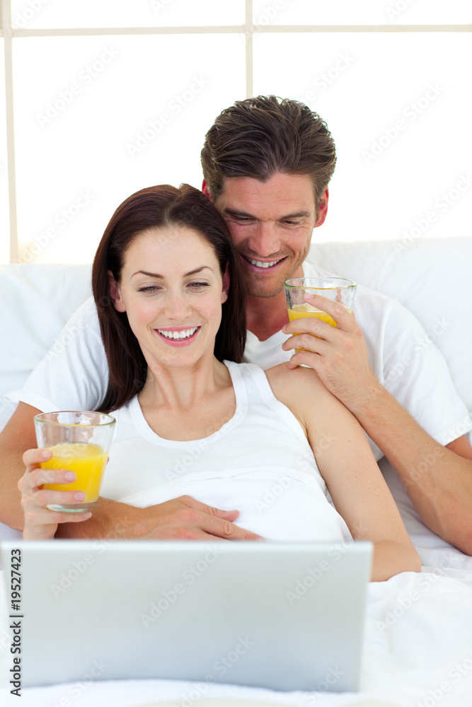 Lovers using a laptop on their bed Lovers using a laptop on their bed