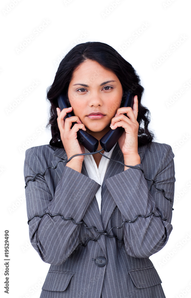 Stressed businesswoman tangled up in phone wires Stressed businesswoman tangled up in phone wires