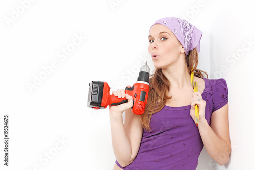 Obraz na plátně woman with drill doing home improvement