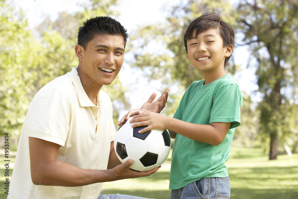 Obraz premium Father And Son In Park With Football