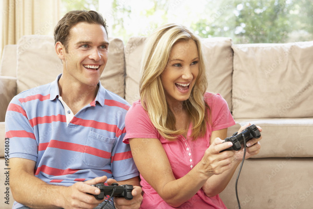 Young Couple Playing Computer Game On Sofa At Home Stock Photo Adobe Young Couple Playing Computer Game On Sofa At Home Stock Photo Adobe