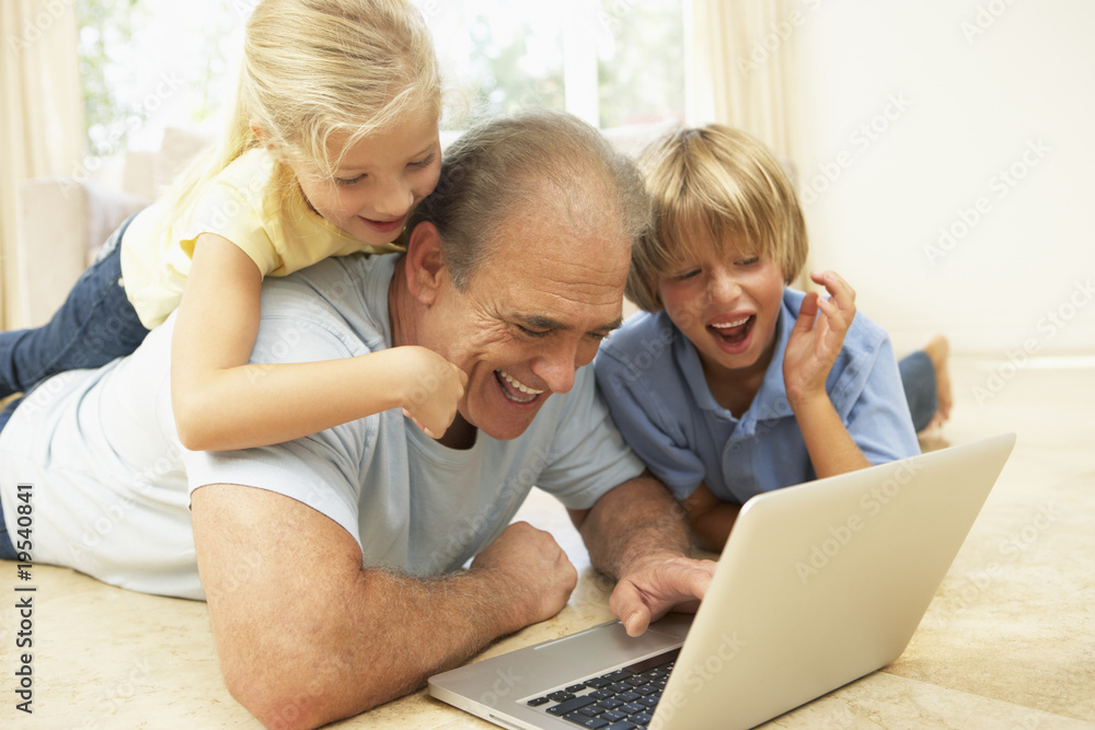 Grandfather AndGrandchildren Using Laptop At Home Grandfather AndGrandchildren Using Laptop At Home