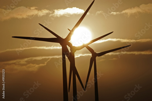Wind turbines silhouetted against a sunset