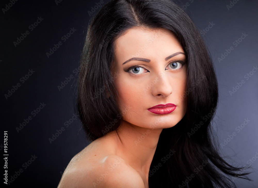 Beautiful young woman face over dark background Beautiful young woman face over dark background