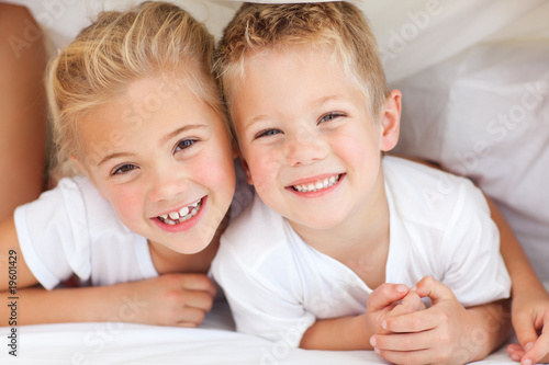 Adorable siblings playing on a bed