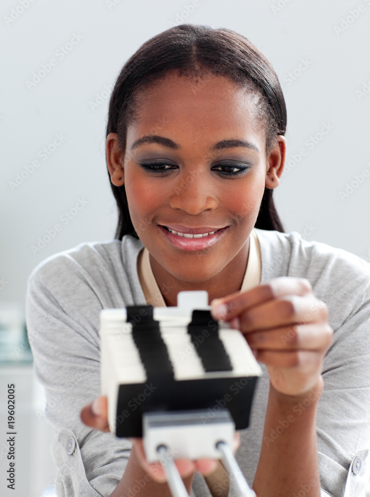 Positive businesswoman consulting a business card holder Positive businesswoman consulting a business card holder