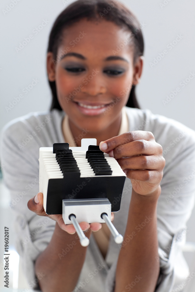 Ethnic businesswoman consulting a business card holder Ethnic businesswoman consulting a business card holder