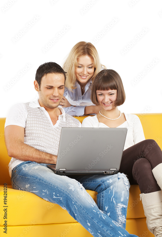 Three smiling friends with laptop computer