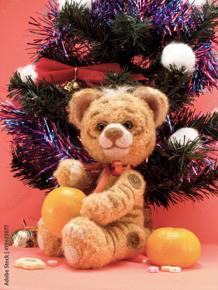 Toy tiger with oranges under a fur-tree Toy tiger with oranges under a fur-tree