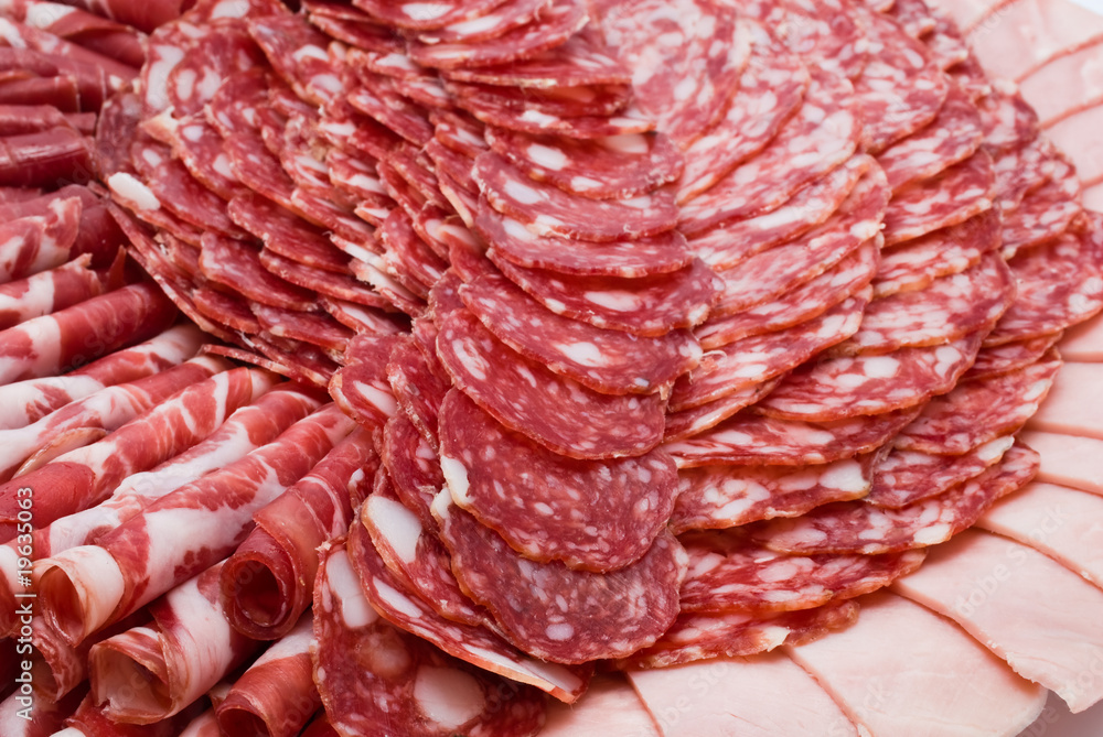 Cutting sausage and cured meat on a celebratory table Cutting sausage and cured meat on a celebratory table