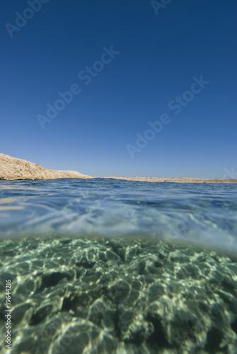 Split view desert coastline blue water