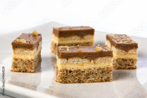 pieces of a chocolate and vanilla pudding cake with walnuts bisc