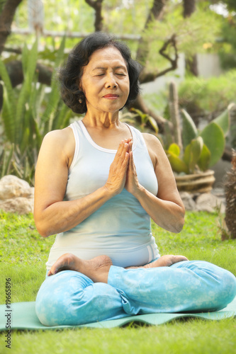 Asian senior woman meditating for yoga outside