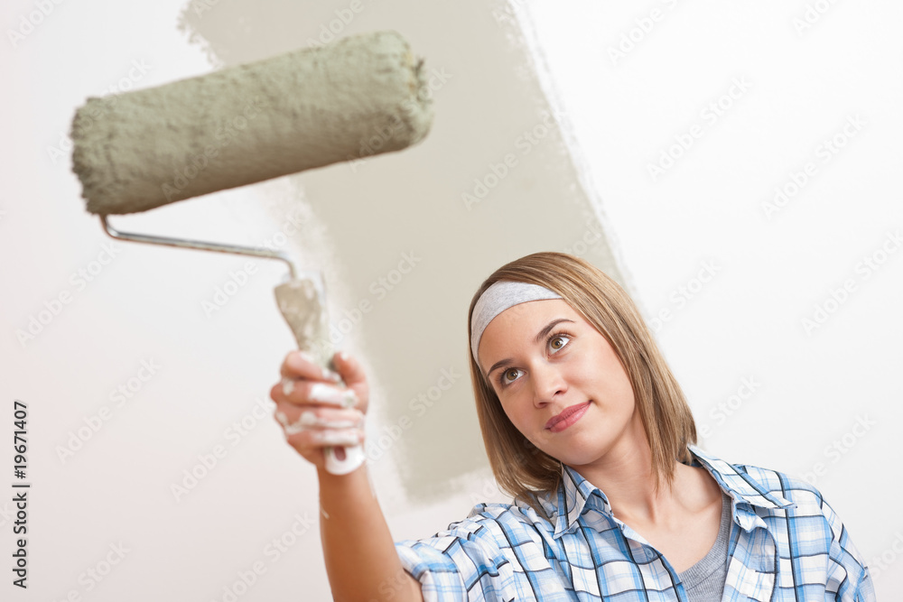 Home improvement: Young woman with paint roller Home improvement: Young woman with paint roller