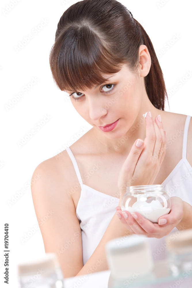 Body care: Young woman with jar of moisturizer in bathroom Body care: Young woman with jar of moisturizer in bathroom