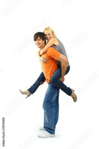 Happy young female enjoying a piggyback ride on boyfriends back