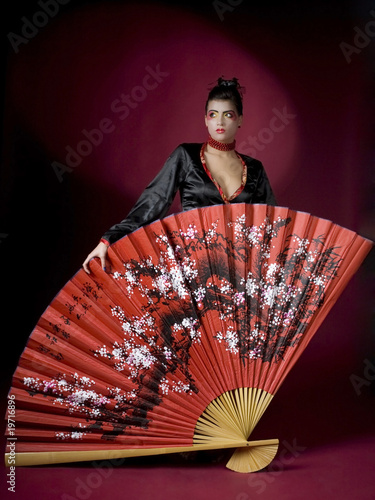 Geisha with huge fan in studio