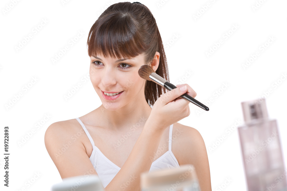 Body care: Young woman applying powder with brush Body care: Young woman applying powder with brush