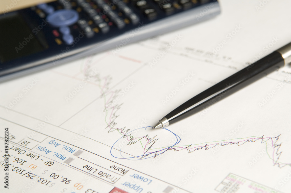 Share price with calculator and pen Share price with calculator and pen