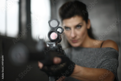 stylish woman holding an assault rifle © Peter Kim