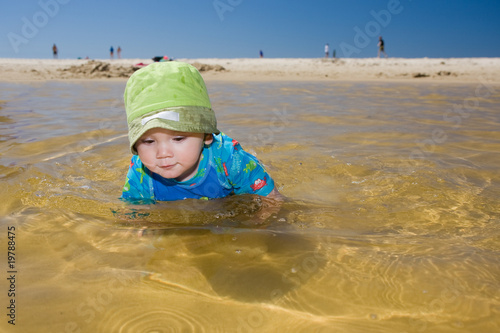 Baby swimming at beach photo