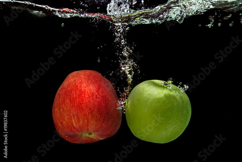ref and green apple dropped into water with splash