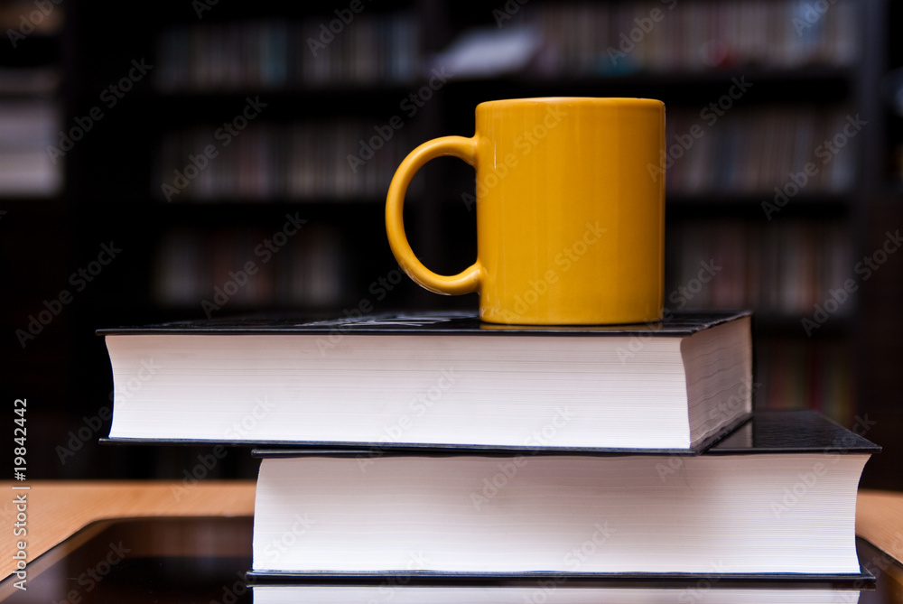 mug of coffee on the stack of books mug of coffee on the stack of books