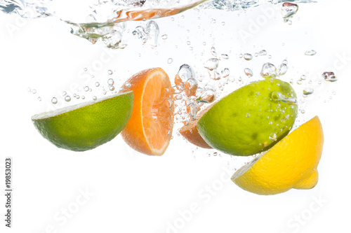 Citrus fruit falling into clear water