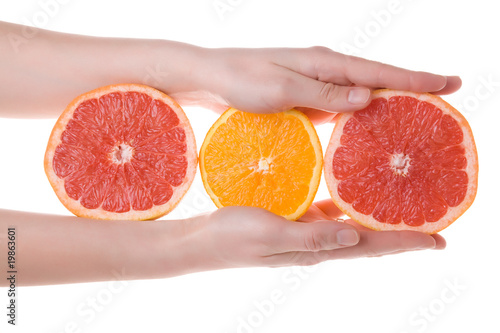 Hands holding sliced orange and grapefruit