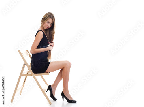 Young blonde girl sitting on a chair