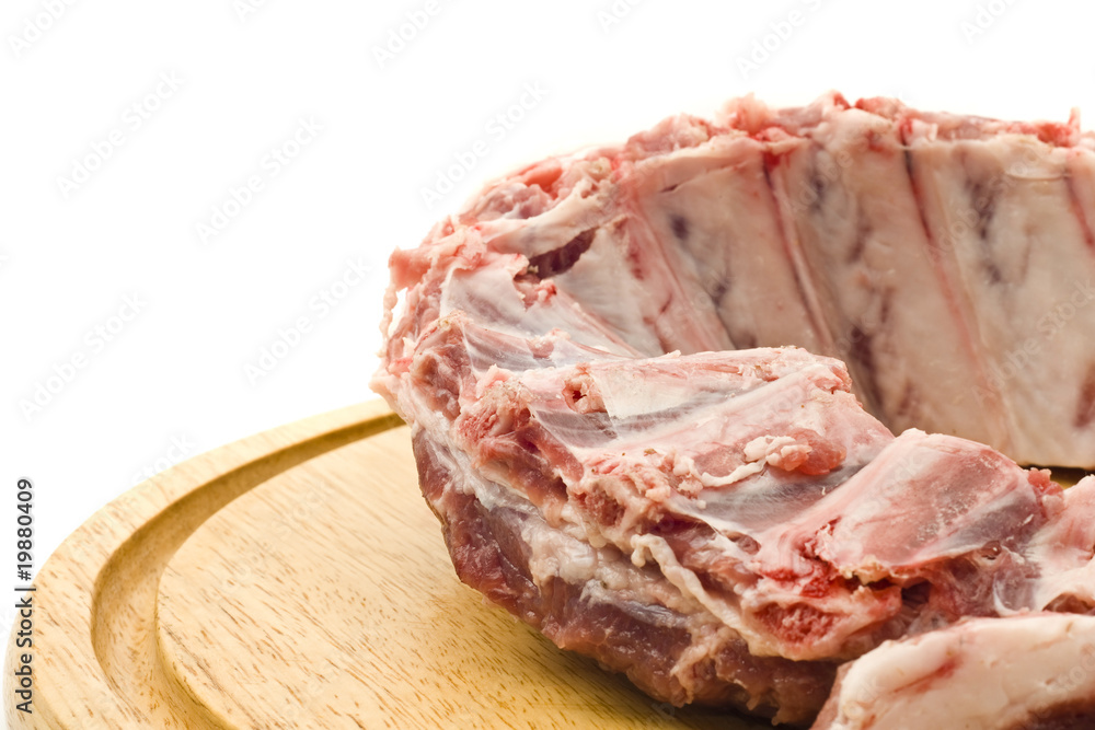 Pork ribs with raw meat on round hardboard Pork ribs with raw meat on round hardboard