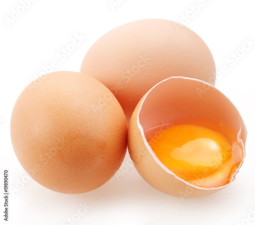 With brown eggs on a white background. One egg is broken.