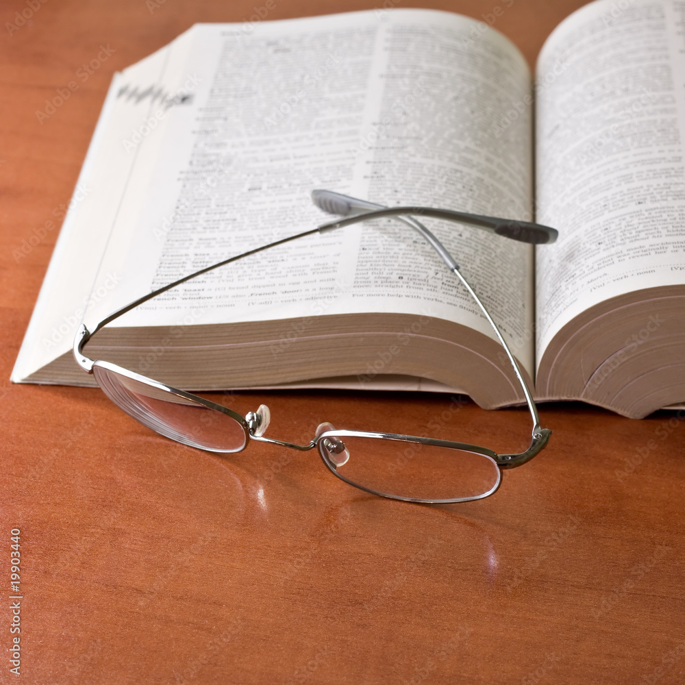 closeup of opened book and glasses