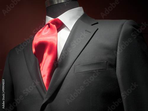 Dark grey jacket with white shirt and red tie