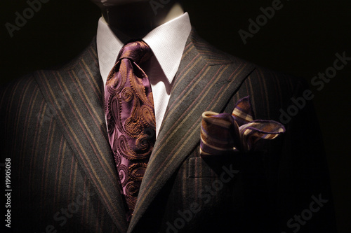 Dark brown striped jacket, purple tie and handkerchief.