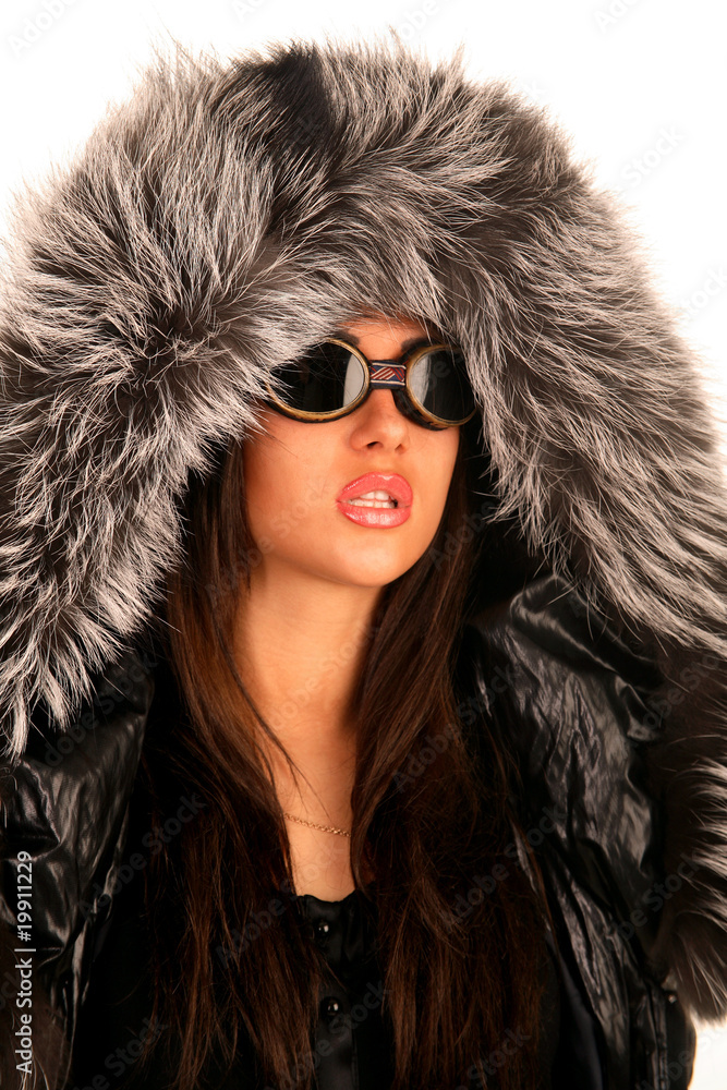 The young girl in sunglasses and a fur hood The young girl in sunglasses and a fur hood