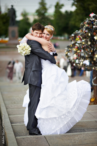Happy bride and groom at wedding walk on Luzhkov bridge Fototapeta