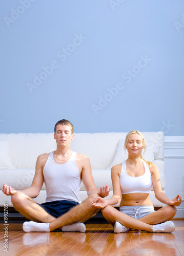 Young Couple Sitting on Floor Meditating