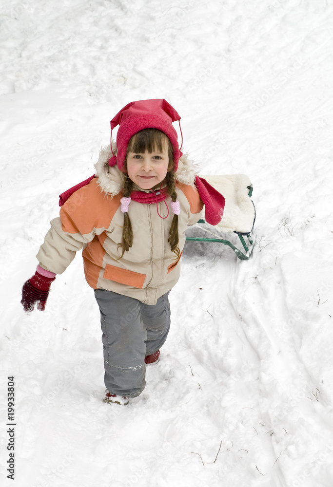 Little girl with a sled climbs a snow-covered hill. Little girl with a sled climbs a snow-covered hill.