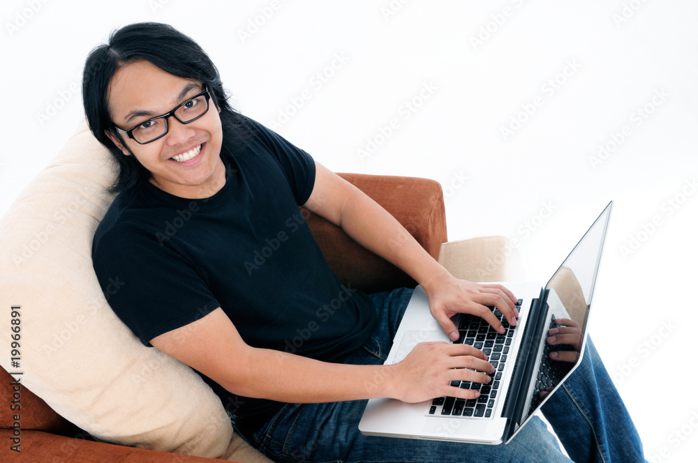 Naklejka premium Happy young man using laptop.