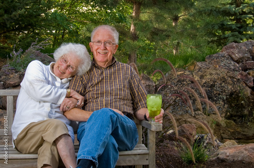 Elderly man and woman sitting on a bench