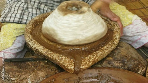 MUJER MOLIENDO EL FRUTO DEL ARBOL DE ARGAN