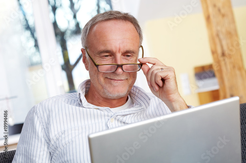 mature man with laptop and eyeglasses